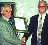 Mr Hart (left) of Technique Electronics receives the certificate from Dr Stutterheim